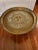 Antique Asian handcrafted brass tray table, circa 1920-30s. The tray is engraved with varying intricate hand carved floral...