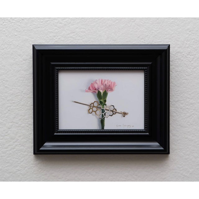 In "The Golden Hive," a delicate pink carnation is elegantly juxtaposed with a geometric honeycomb structure, creating a...