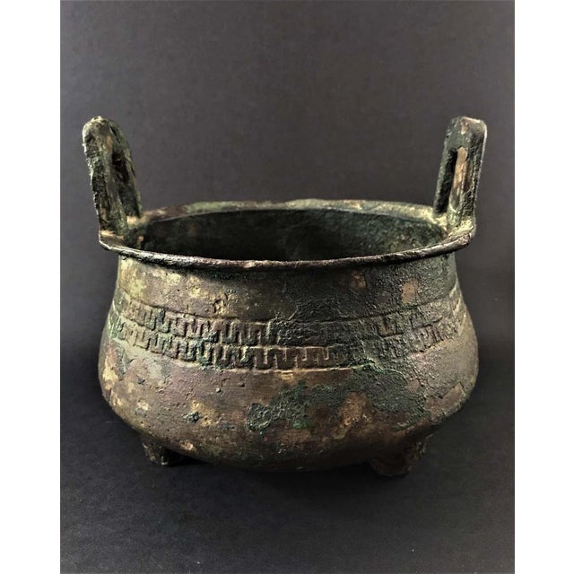 Bucket burns perfume in bronze resting on three feet. The body is sculpted with a band frieze with an archaic motif. Two...