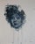The artwork features a striking portrait of a figure with voluminous, curly hair, rendered in a palette of deep blues and...