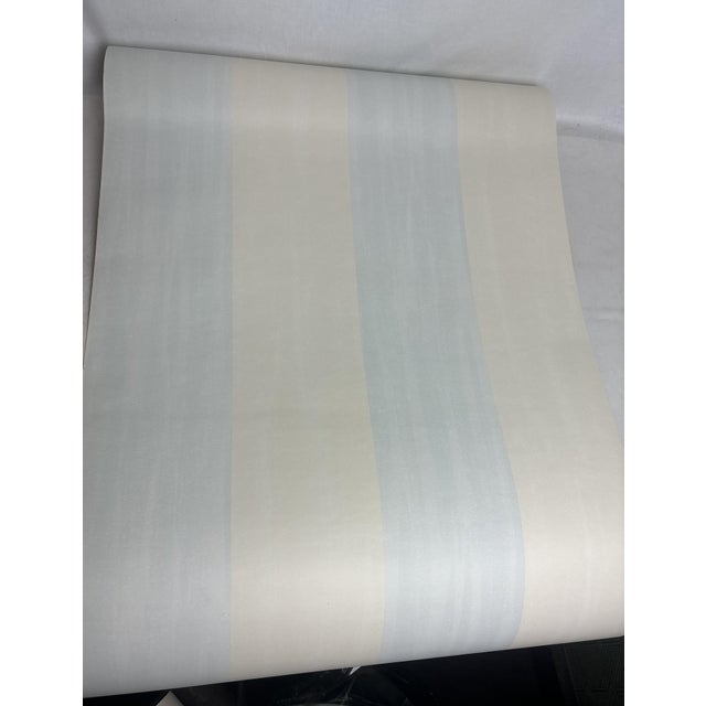 Gorgeous Osborne & Little wallpaper with thick painterly stripes in a pale blue and very light yellow. This is a ready-...