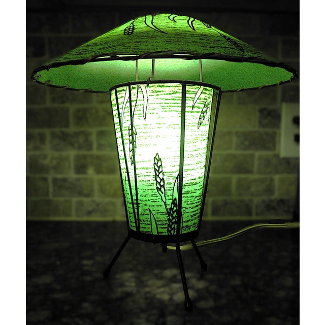 Fiberglass 1950s atomic era metal tripod fiberglass-shaded lamp. The rounded top saucer shade attaches to the framework of...