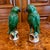 A delightful pair of green glazed Chinese Export earthenware parrots standing on bits of rockery glazed in pale ochre with...
