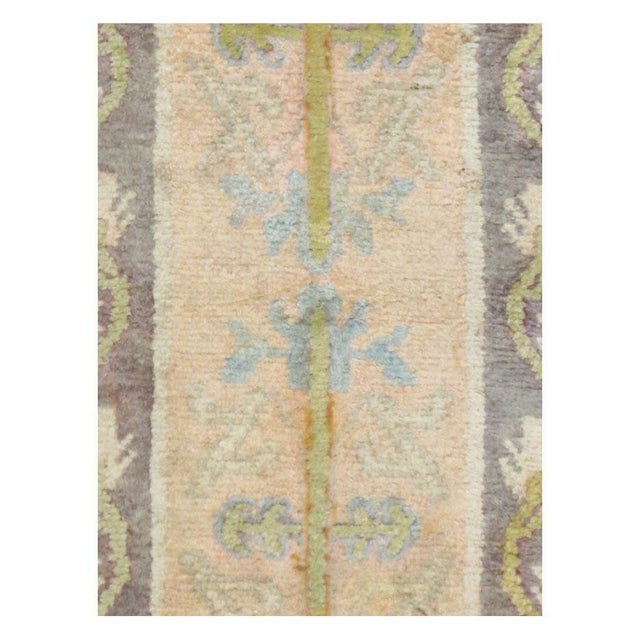 A vintage East Turkestan Khotan rug in runner format handmade during the mid-20th century. The design is unusual for a...