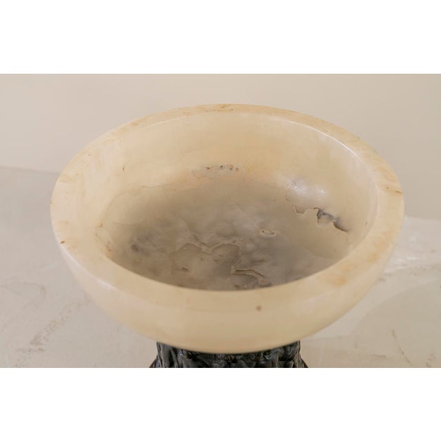 Onyx mouth cup with a patinated bronze foot with a row of putti in different positions. Golden metal base.