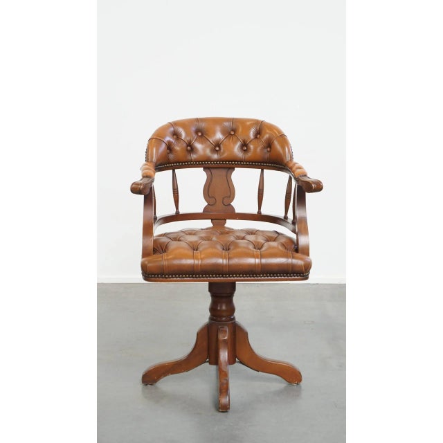 Offered this classic cowhide leather and wood Chesterfield office chair in English style, finished with decorative rivets....