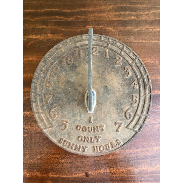 A stunning vintage iron garden sundial reading, "Let others tell of storms and showers, I count only sunny hours." By...