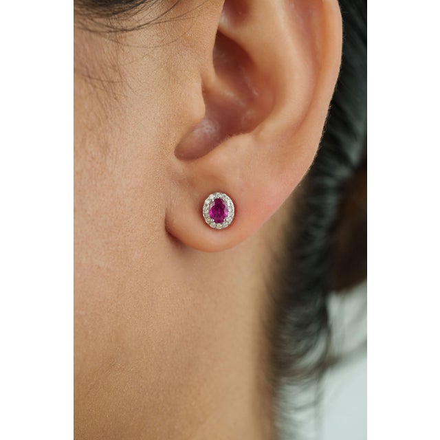 These stud earrings showcase 0.71 carats of natural oval-cut vivid red rubies, set in 18K white gold. Each ruby measuring...