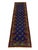 This tribal Oriental wool runner features two columns of repeating Mori Gul medallions across a vivid cobalt-blue field....