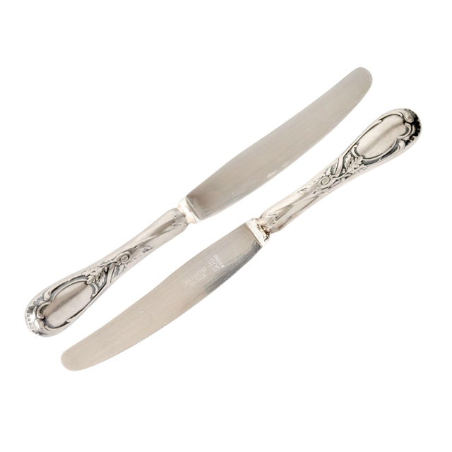 Elegant set of twelve antique French dinner knives featuring silverplated handles paired with quality Solingen stainless...