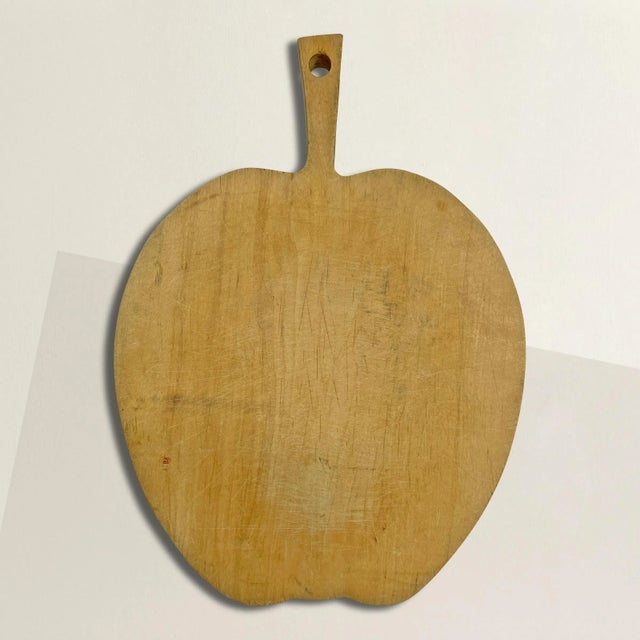 A quaint early 20th century English maple apple cutting board perfect for chopping fruits and veggies, or serving...