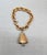 Goldtone Florentine finish bell charm with a faceted glass clapper with a rhodium plated filigree cap at the top on a...