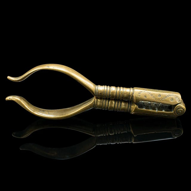 This is a small pair of antique pistachio nutcrackers. An English, brass hand tool, dating to the Georgian period, circa...