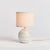 With a petite ceramic body and a soothing taupe glaze, this lamp adds warmth to any setting. Topped off with a natural...