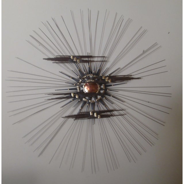 Vintage Mid Century Modern Metal wall art depicting the radiating sun and clouds in colors of gold copper and grey. The...