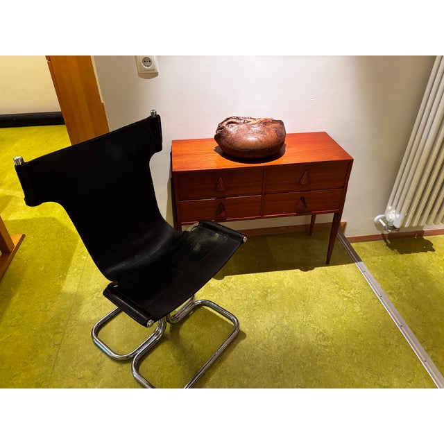 Chair with a bold design, chromed tubular frame and ergonomic seat in patinated black leather; an aesthetic that is both...