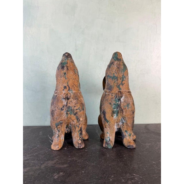 A charming pair of cast iron rabbit sculptures, rendered in a stylized, almost folk-art form with softly rounded bodies...
