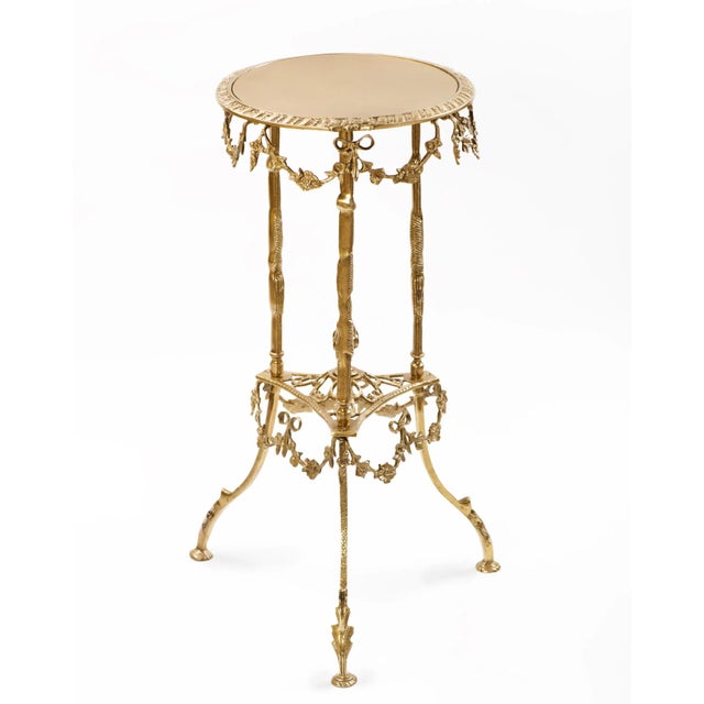 A Spanish highly decorative bronze table with brass top features a nicely carved apron with hanging floral swags. The...
