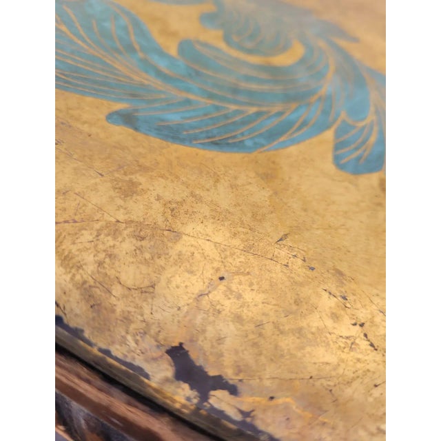 Round coffee table with the wooden base carved with a floral decor, and painted, surmounted by a tray in eglomized glass...