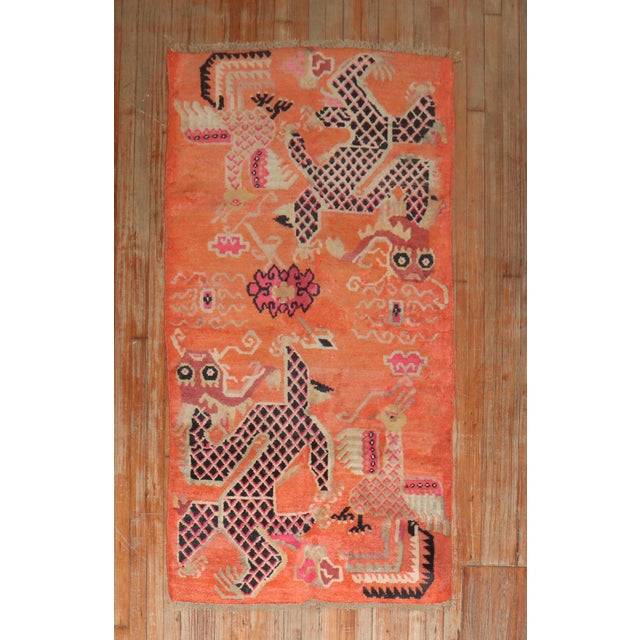 Colorful one-of-a-kind Tibetan rug from the 2nd quarter of the 20th century with a dragon motif on a bright orange field...