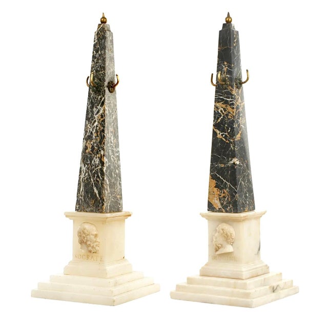 A Pair Of 19th Century Black Variegated Marble Grand Tour Obelisks with applied bronze finials and hooks. Each features...