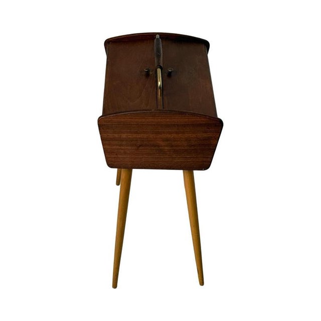Ca. 1960’s side table with special storage for sewing supplies that can be accessed by opening the top. Mounted on four...