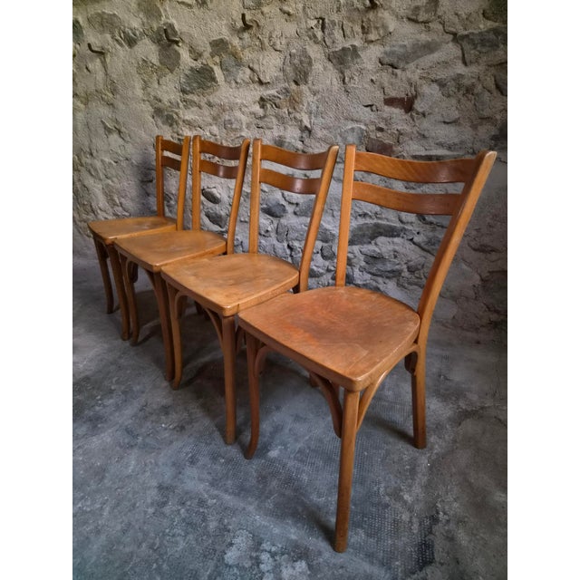 A set of four French bistro chairs with matching stool by Baumann, dating from the 1950s. Made from beech wood, the chairs...