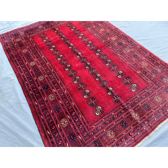 This hand-knotted Bokhara rug features three tidy columns of small octagonal "elephant's foot" guls in navy and ivory, set...