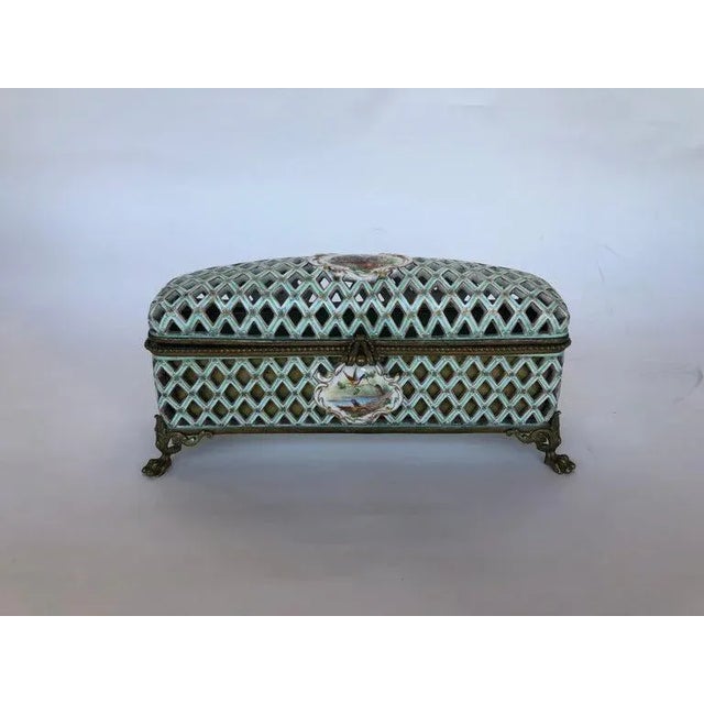 A French metal mounted porcelain box. Hand painted flower arrangement on top of box, front and back.