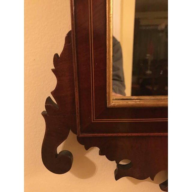 Elegant 19th Century Chippendale style mahogany mirror. The gilt swan neck pediment with rosette and urn motif, flanked by...