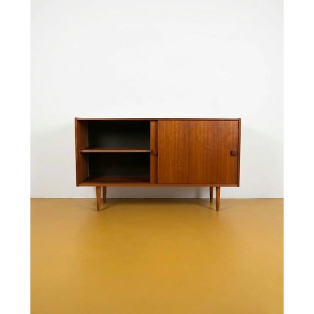 A 1960s Danish teak sideboard with two sliding doors and tapered legs in light wood—a combination typical of quality mid-...