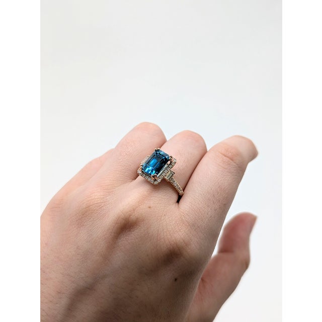 Make a bold statement with this dazzling 6.7-carat blue zircon ring, set in warm 14K rose gold. Surrounded by a halo of...