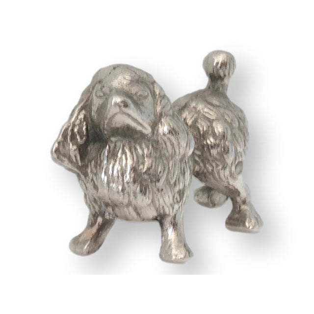 This vintage English silverplate toy poodle figurine brings a charming touch of canine elegance to your collection....