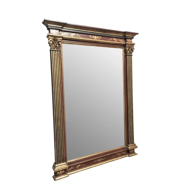 An Italian hand-painted mirror framed with Corinthian columns and a stepped crown. Gold accents on a dark burgundy frame.
