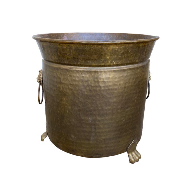 Antique brass animal-footed jardinière with lion motifs and ring handles. The brass is tarnished and hammered with a light...