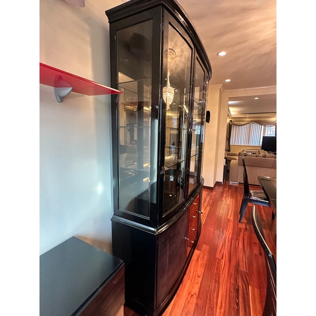 The upper cabinet features three glass-panel doors with keyholes for security, opening to multiple levels of glass...