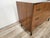 An elegant small chest of drawers dating back to the 1960s, characterized by clean lines, compact proportions, and the...