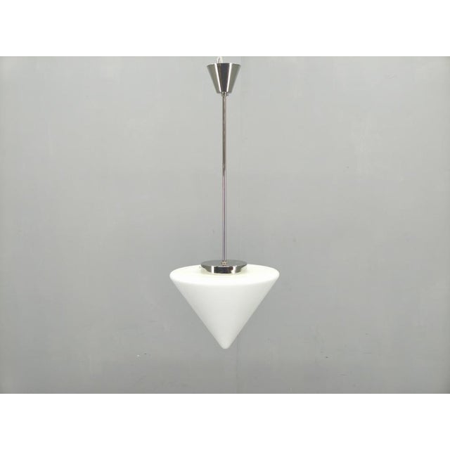 A refined Art Deco style pendant light produced in Czechoslovakia during the 1970s. This piece features a sleek chrome-...