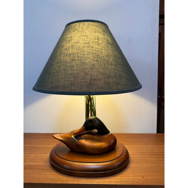 Design Plus Gallery presents the Duck Decoy Table Lamp from Turkey Swamp. The lamp has a wood duck that is looking down...