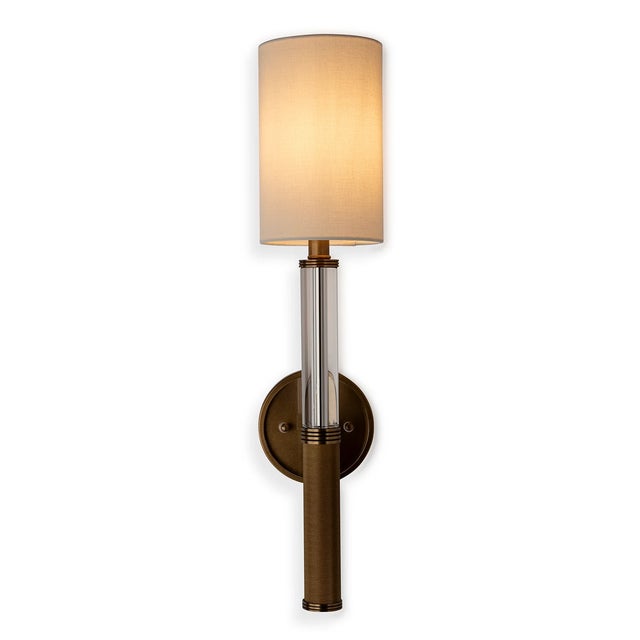 Mid century, modern style narrow column sconce featuring a crystal turning joined with aged brass finished knurled...