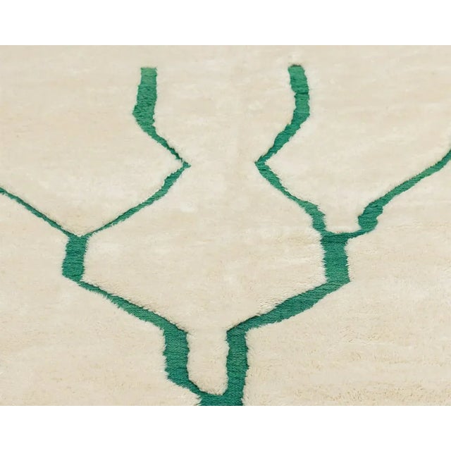 Artistic hand-knotted wool rug in a soothing Ivory background, showcasing a minimalist Jade Jubilee Green tree design....