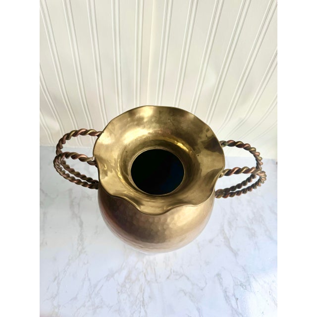 Add timeless elegance to your space with this striking hammered brass vase, featuring two twisted copper handles and a...