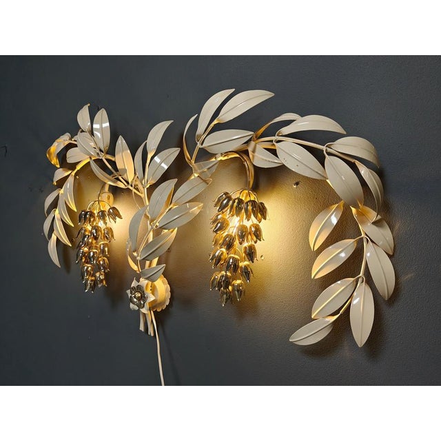 Vintage white metal and gold wall lamp by Hans Kögl with leafs and tulips. The wall lamp has 2 light points. Tested and...
