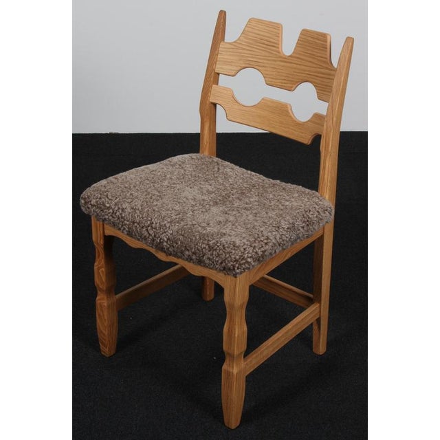 Set of striking dining chairs by Henning Kjærnulf, made of oak and Sahara coloured lambskin. Refreshing design with bold...