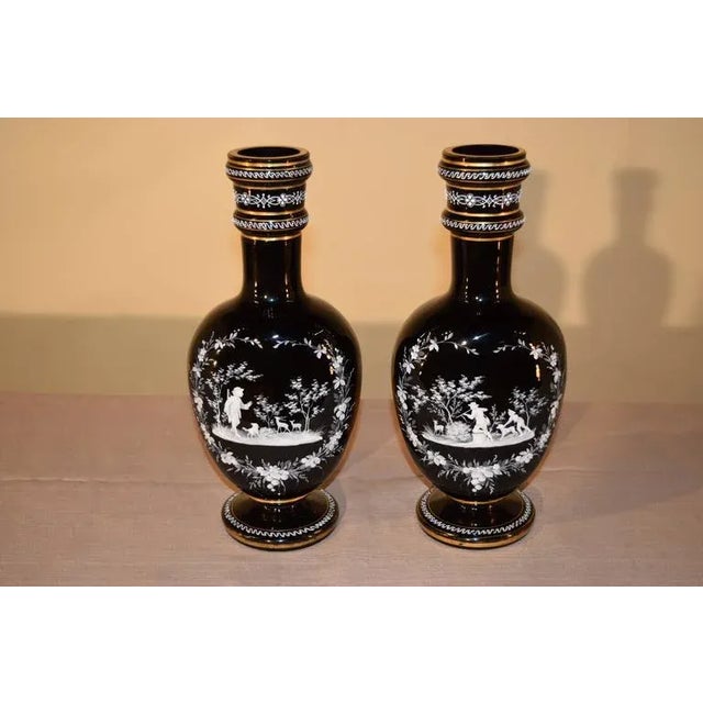 Pair of 19th century handblown amethyst glass vases with central designs on the front surrounded by a floral border and...