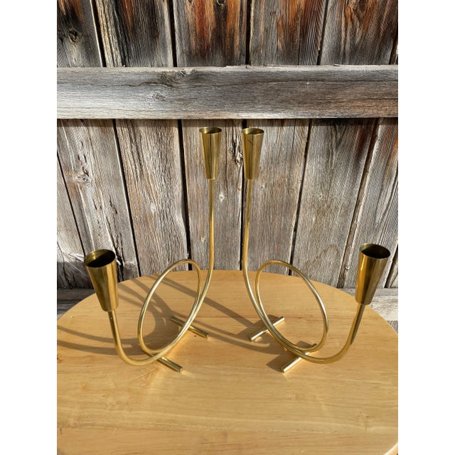 Pair of mid century modern circular candelabras. Each candelabra has offset heights of the candles making for a stringing...