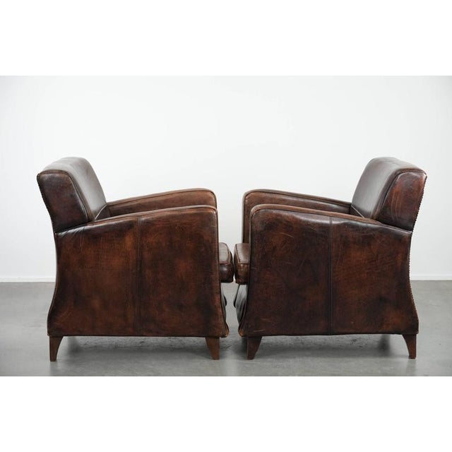 We are offering this distinctive set of two sleekly shaped sheepskin leather designer armchairs with beautiful deep colors...