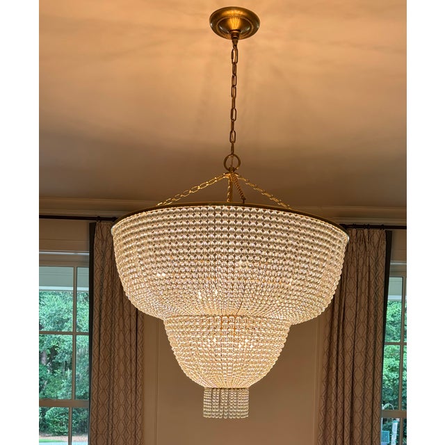 This stunning modern glass chandelier with hand rubbed antique brass trim will be a center piece to room. It is 38” high...