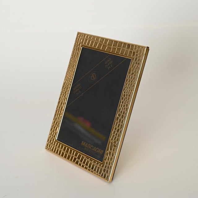 Wonderful and incredibly rare photo frame in 24K gold-plated brass with a crocodile faux leather effect. Designed by...
