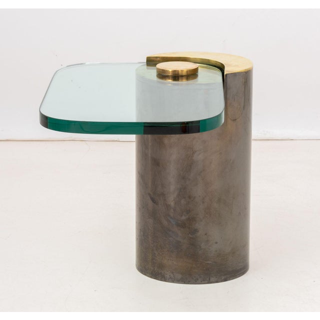 Karl Springer Sculptural End Table, with glass top and gilt and gunmetal-tone brass cylindrical base. 18.25" H x 24" W x...